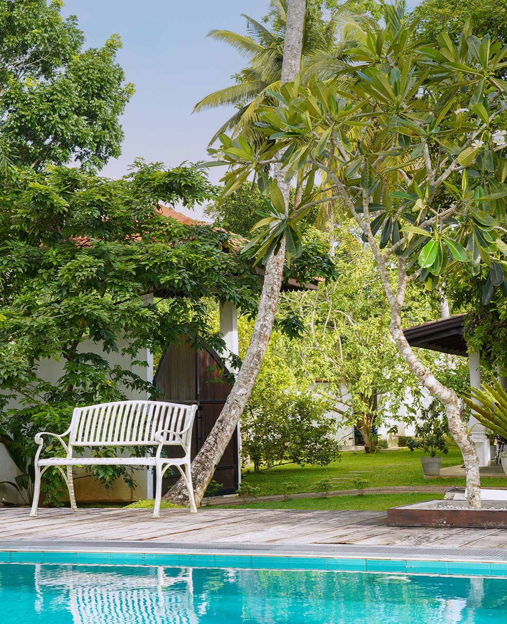 The villa's covered veranda and whitewashed walls beneath a traditional hipped clay-tile roof