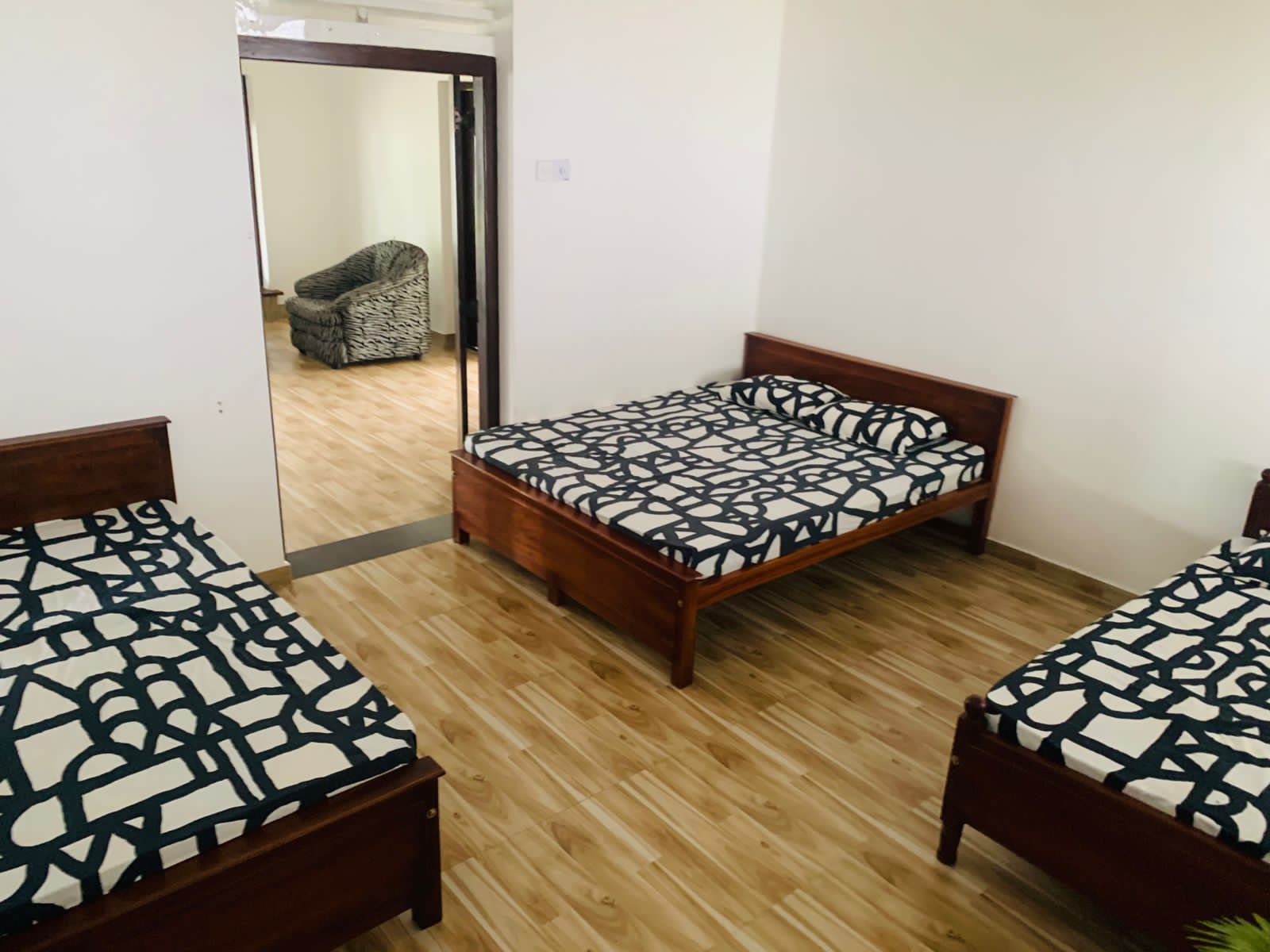 The Family Room at Echoing Dream Resort, with three separate double beds and an adjoining sitting area